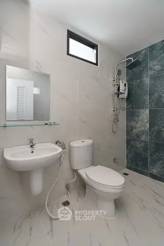 Modern bathroom with sleek fixtures and marble-style tiles