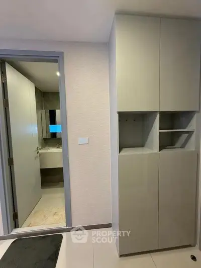 Modern bathroom entrance with sleek storage cabinets in a contemporary apartment.