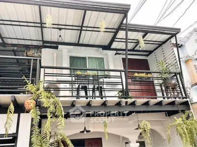 Charming urban balcony with modern railing and lush hanging plants, perfect for relaxation and outdoor dining.
