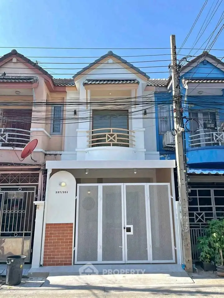 Charming townhouse exterior with modern facade and gated entrance in a vibrant neighborhood.