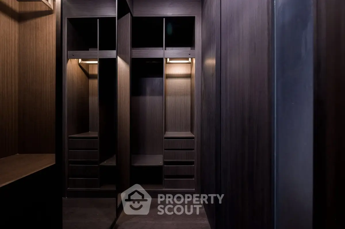 Luxurious walk-in closet with dark wood finish and ample storage space.