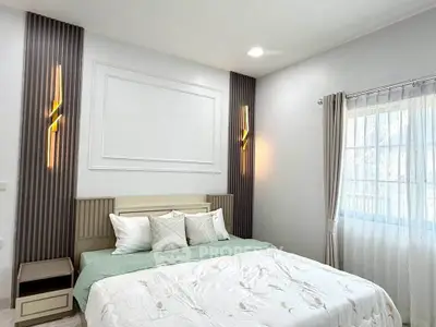 Modern bedroom with stylish lighting and cozy bedding in a bright, airy space.