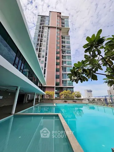 Luxurious high-rise building with stunning pool and lush greenery, perfect for modern urban living.