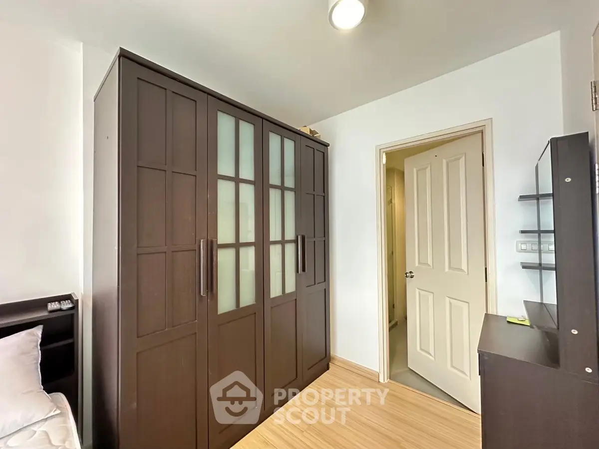 Spacious bedroom with elegant dark wood wardrobe and modern decor
