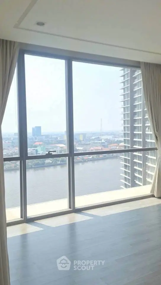 Spacious high-rise apartment with stunning river view and floor-to-ceiling windows.