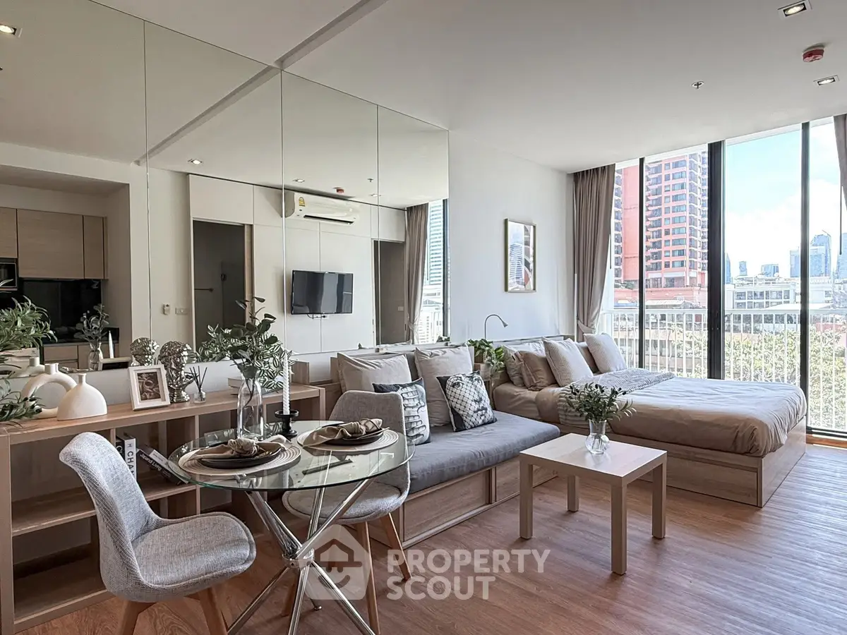 Modern studio apartment with open layout, featuring a cozy living area and bedroom with city view.