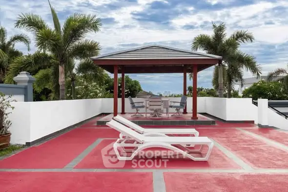 Luxurious rooftop terrace with stylish lounge chairs and gazebo, perfect for relaxation and entertainment.