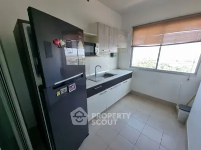Modern kitchen with sleek black fridge and large window view