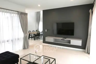 Modern living room with sleek TV setup and elegant dining area