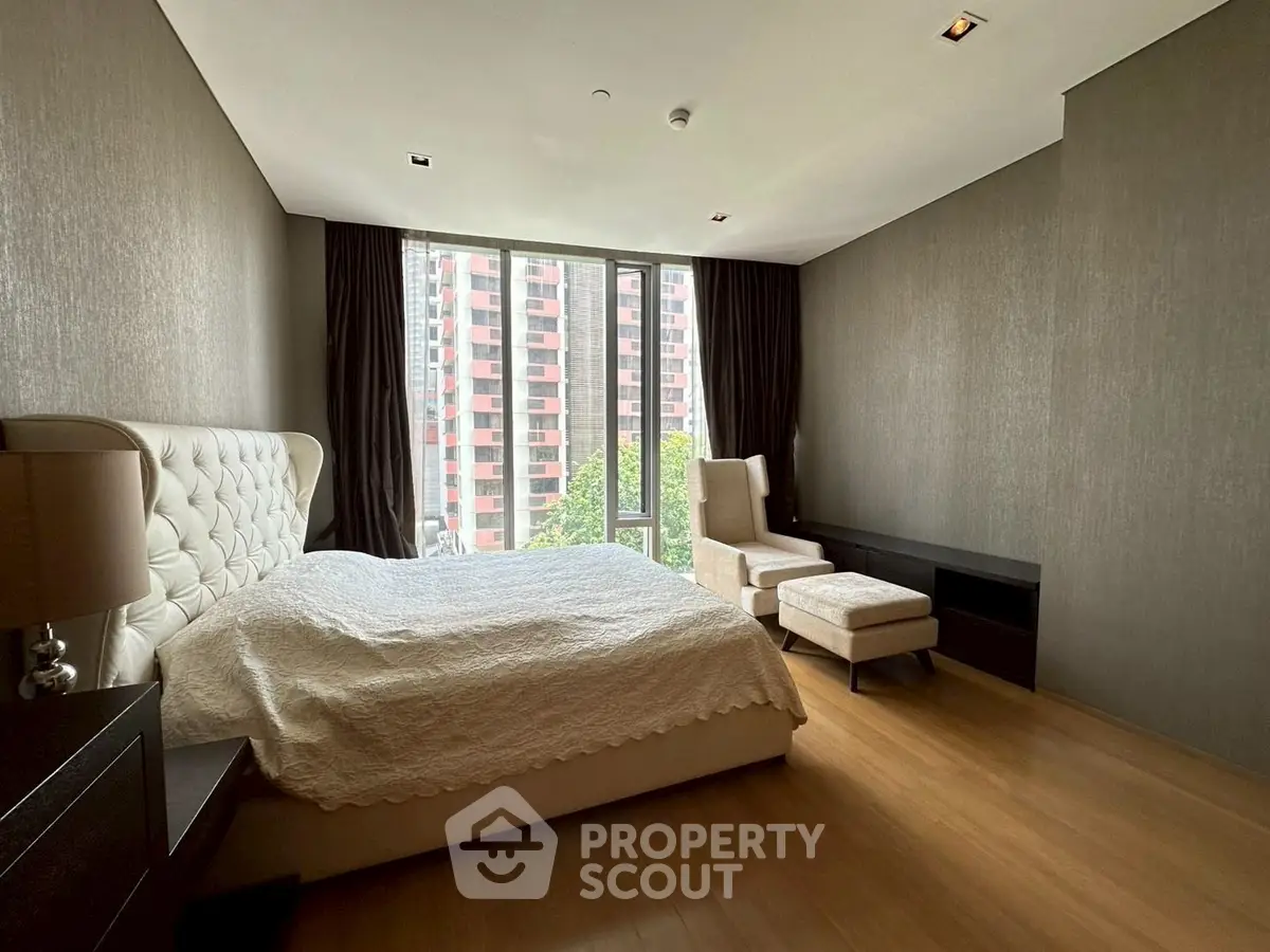 Luxurious bedroom with modern decor and large window offering city view