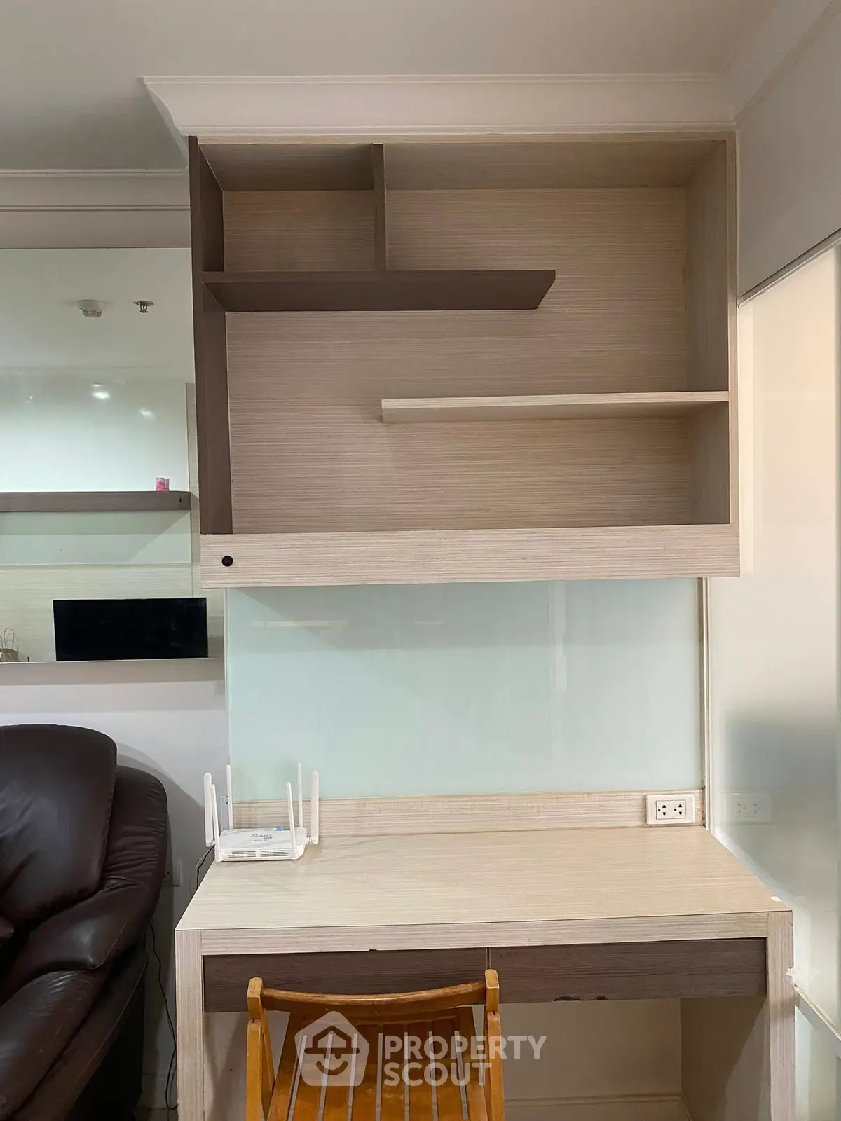 Modern study area with wooden desk and shelves, ideal for home office setup.