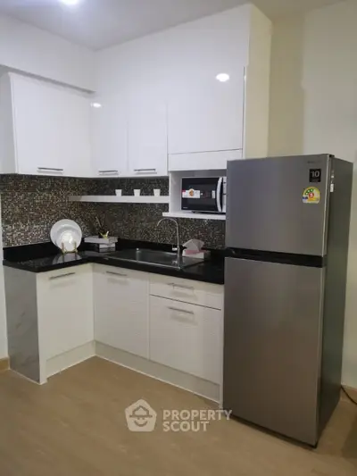 Modern kitchen with sleek cabinets and stainless steel fridge in stylish apartment