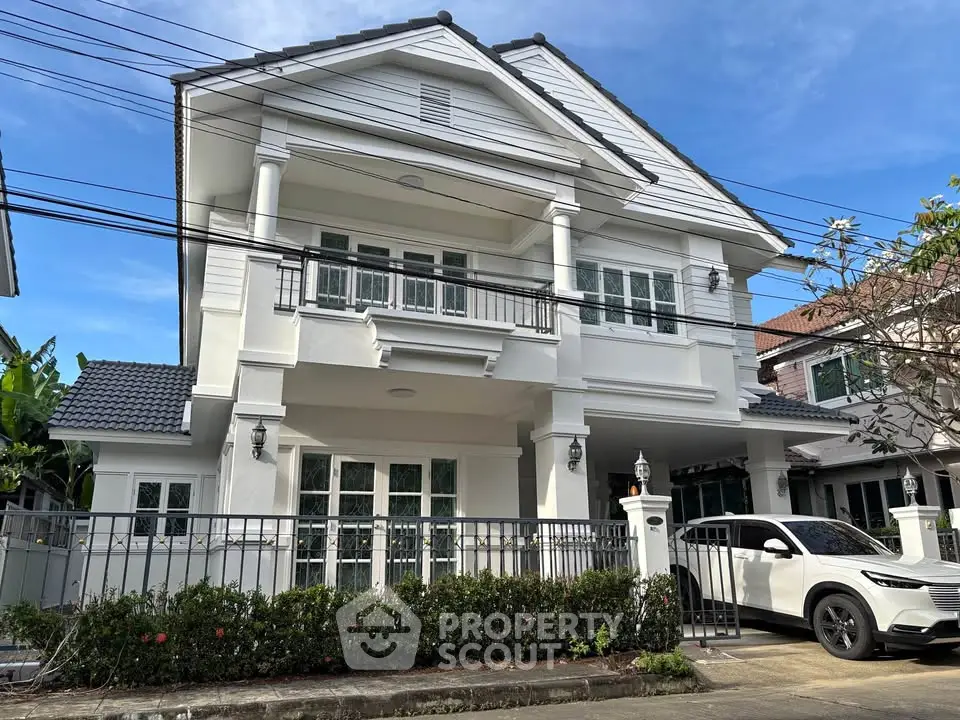 Elegant two-story white house with modern design and spacious driveway.