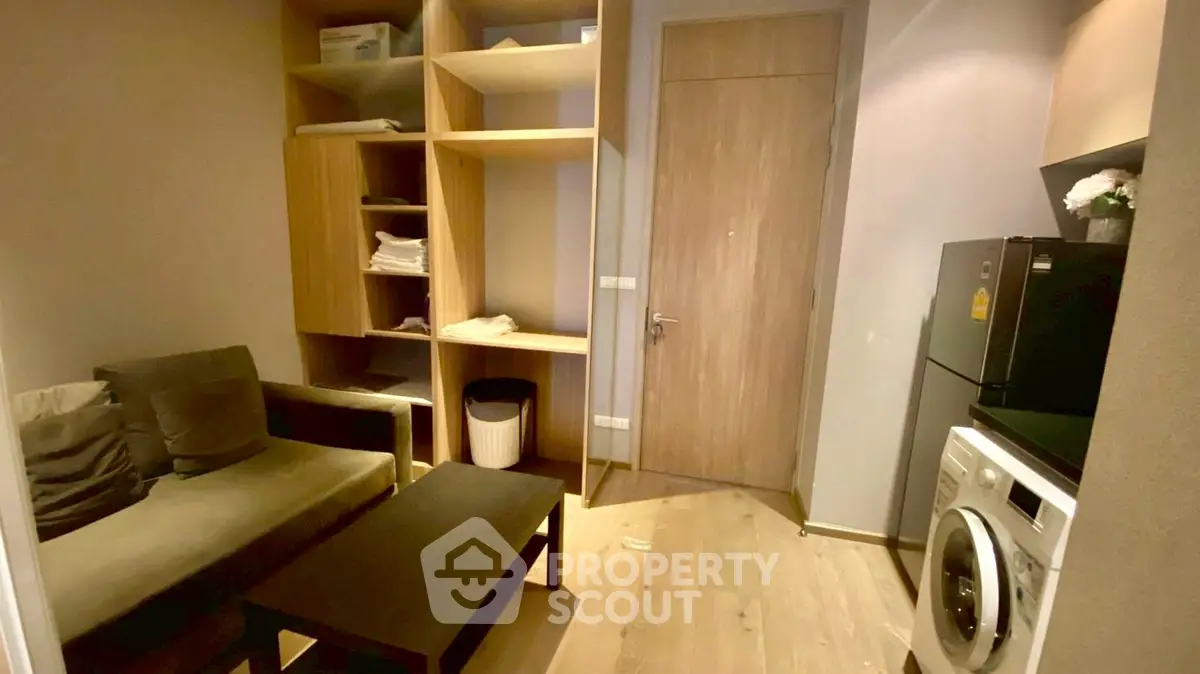 Cozy living room with modern furniture and in-unit washer, perfect for urban living.