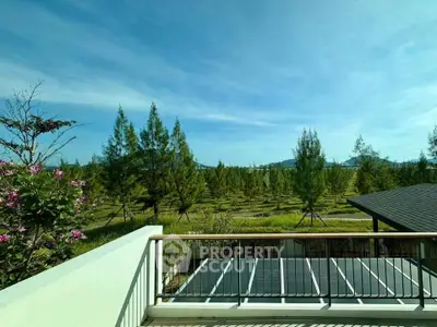 Stunning balcony view overlooking lush greenery and distant mountains, perfect for nature lovers.