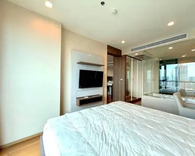 Modern bedroom with city view, featuring sleek design and ample natural light.