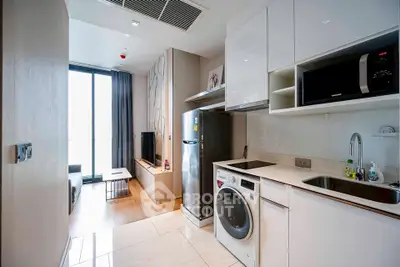 Modern apartment with open kitchen and living area, featuring sleek appliances and natural light.
