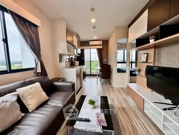 Modern living room with open kitchen, stylish decor, and large windows offering a scenic view.