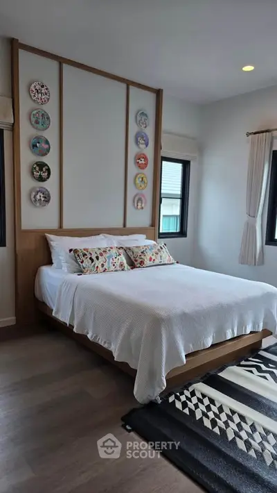 Charming bedroom with stylish decor and natural light, perfect for a cozy retreat.
