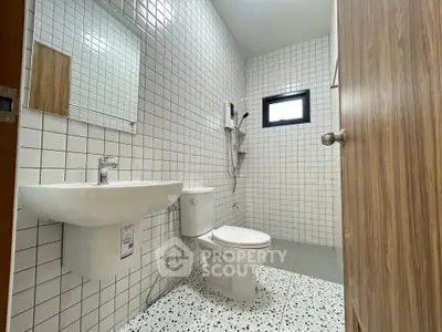 Modern bathroom with white tiles and sleek fixtures