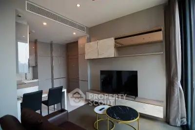 Modern living room with sleek furniture and large TV in a stylish apartment.