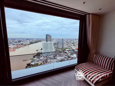 Stunning high-rise apartment with panoramic city and river view from large window.