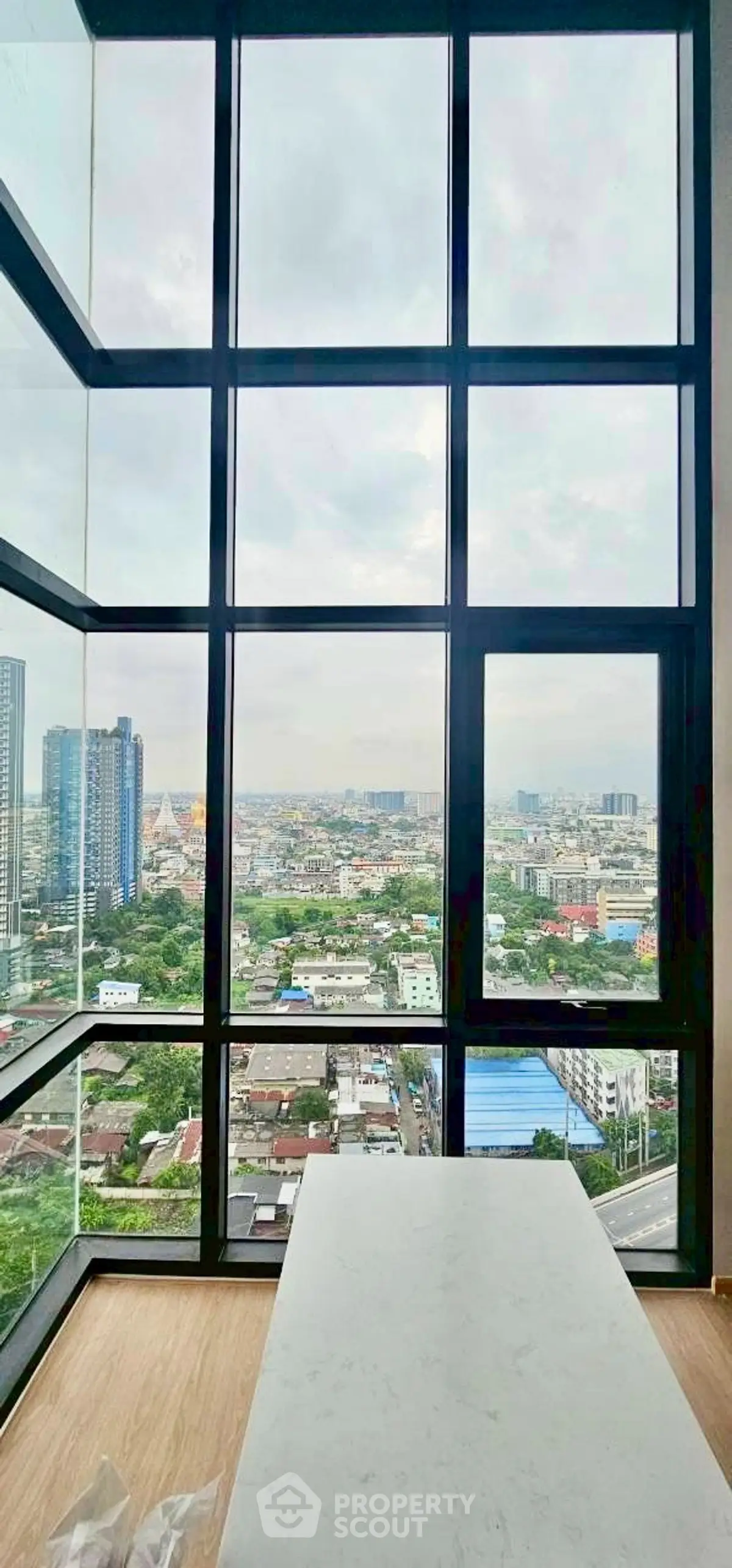 Stunning high-rise view from modern apartment with floor-to-ceiling windows.