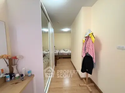 Cozy bedroom with mirrored closet and wooden flooring in modern apartment.