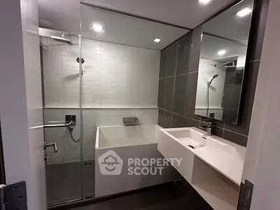 Modern bathroom with sleek design, featuring a glass-enclosed shower and stylish vanity.