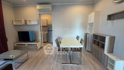 Modern living room with dining area and TV, featuring sleek furniture and neutral tones.