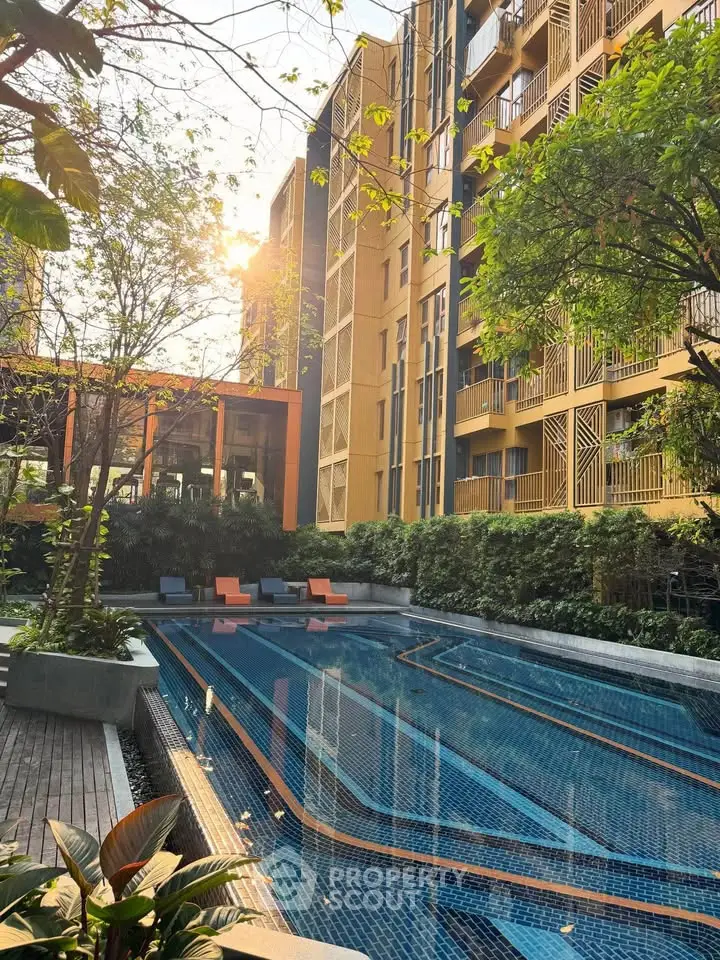 Luxurious apartment complex with serene outdoor pool and lush greenery, perfect for relaxation and leisure.