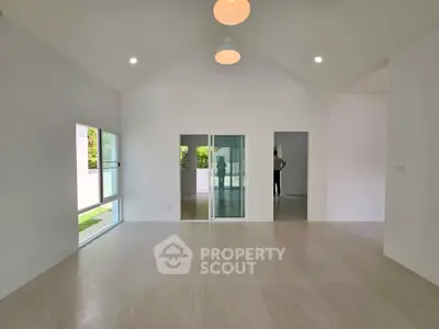 Spacious modern living room with high ceilings and large windows offering natural light.