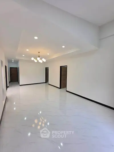 Spacious modern living room with elegant lighting and sleek tile flooring.