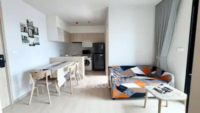 Modern living room with colorful sofa and dining area in open layout apartment