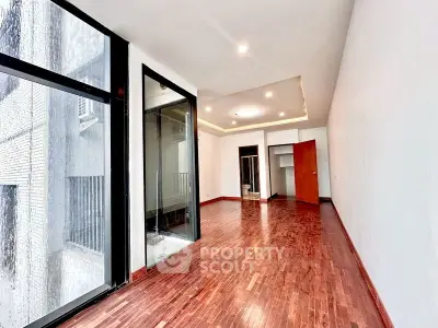 Spacious modern living room with hardwood floors and large windows