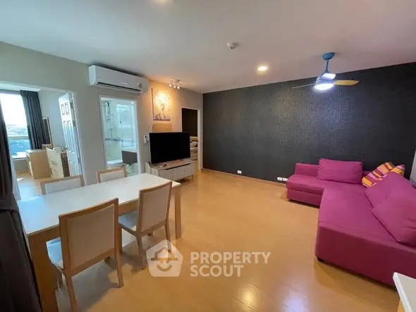 Spacious modern living room with vibrant pink sofa and dining area.