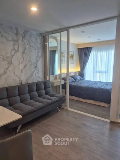 Modern apartment interior with stylish living room and cozy bedroom separated by glass doors.