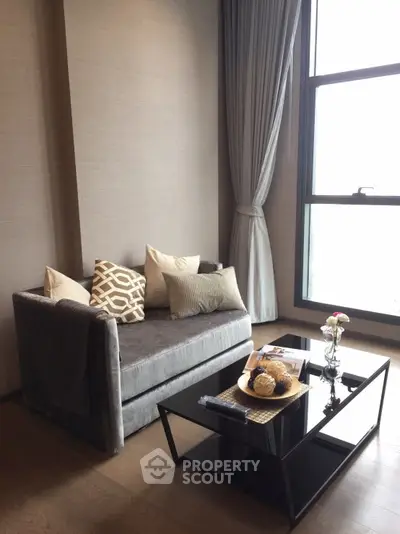 Elegant living room with modern sofa and large window offering natural light.