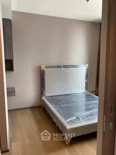 Modern bedroom with new bed frame and wooden flooring in a stylish apartment.