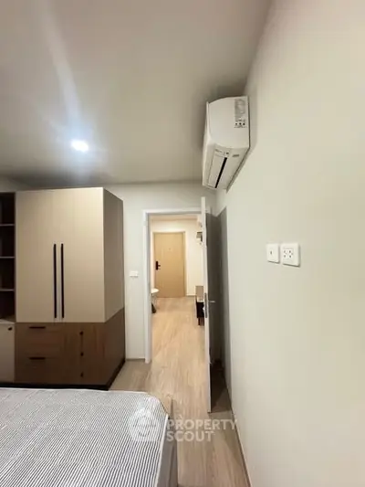 Modern bedroom with air conditioning and wooden flooring