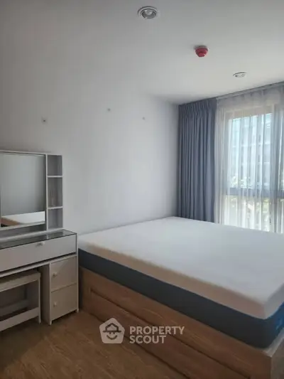 Spacious bedroom with natural light and modern furnishings in a stylish apartment.