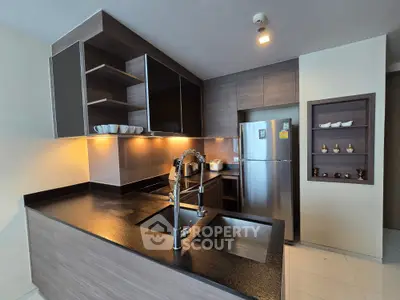 Modern kitchen with sleek cabinetry and stainless steel appliances in a stylish apartment.