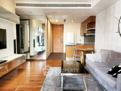 Modern living room with open kitchen, sleek furniture, and wooden flooring in a stylish apartment.