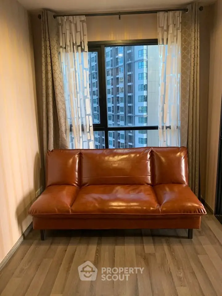 Stylish living room with leather sofa and city view from window