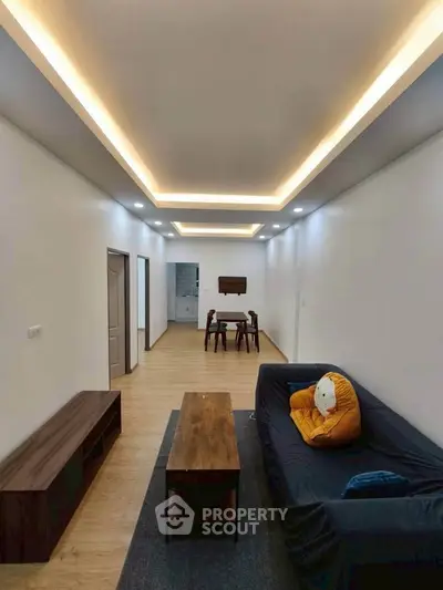 Spacious modern living room with stylish lighting and cozy seating area.