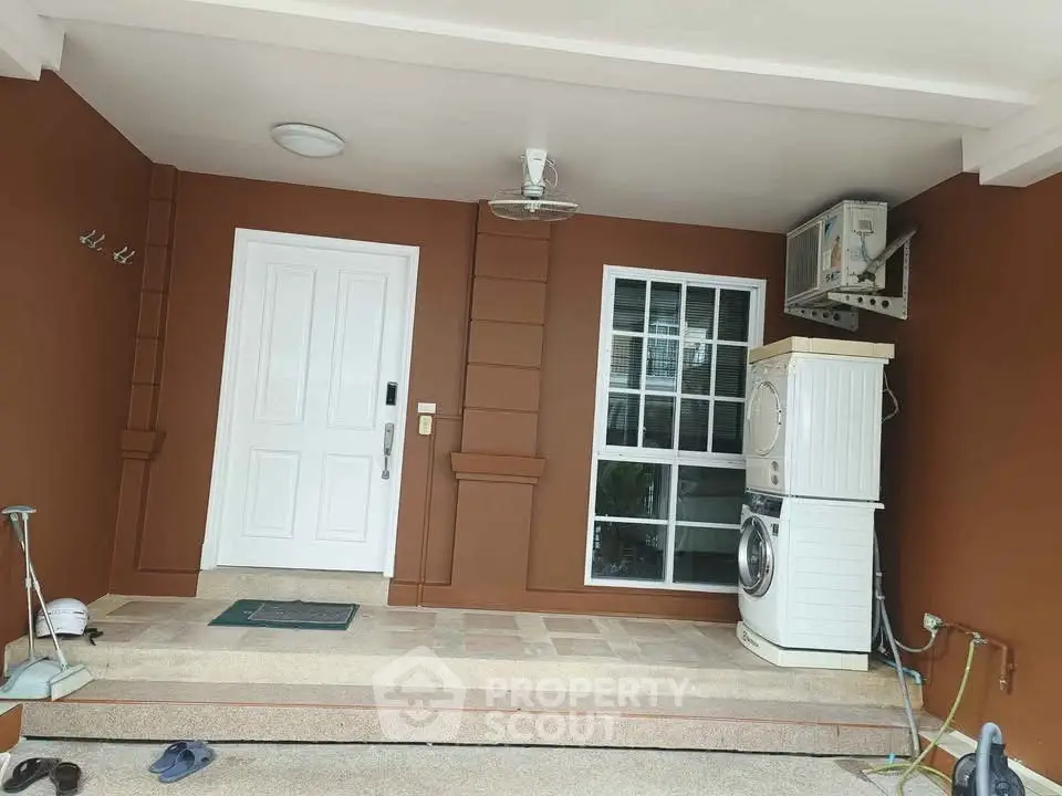 Charming entrance with washing machine and brown walls, perfect for modern homes.