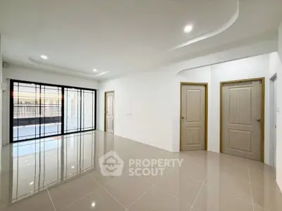 Spacious modern living room with glossy tiled floors and large windows for natural light.