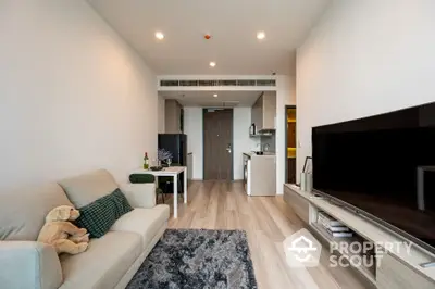 Modern living room with open kitchen, cozy sofa, and stylish decor in a contemporary apartment.