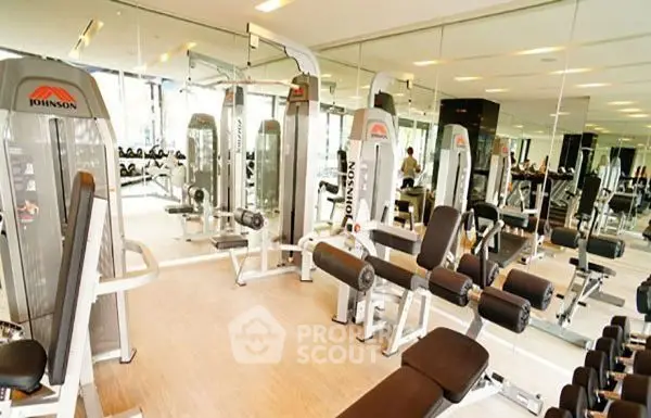 Modern gym with state-of-the-art fitness equipment and mirrored walls in a luxury residential building.