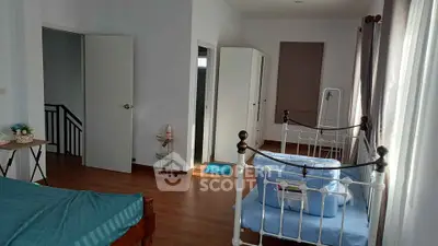 Spacious bedroom with elegant iron bed frames and ample natural light